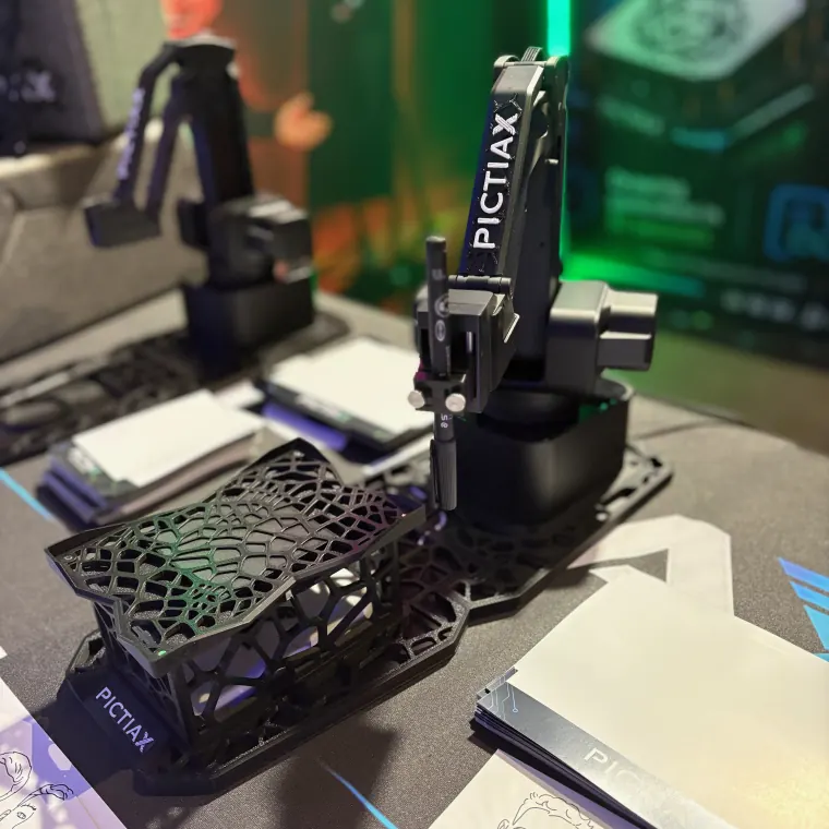 Two PictiaX® robots on the stand at PBX Europe Amsterdam, with their base and branded sheets