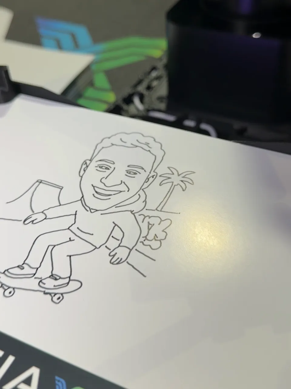 Continuous-line caricature of a person on a skateboard on the paper of the PictiaX® robot base