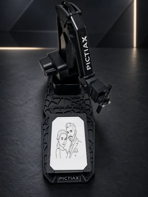 El brazo robótico de PictiaX® sobre su base, con una caricatura ya trazada en la hoja